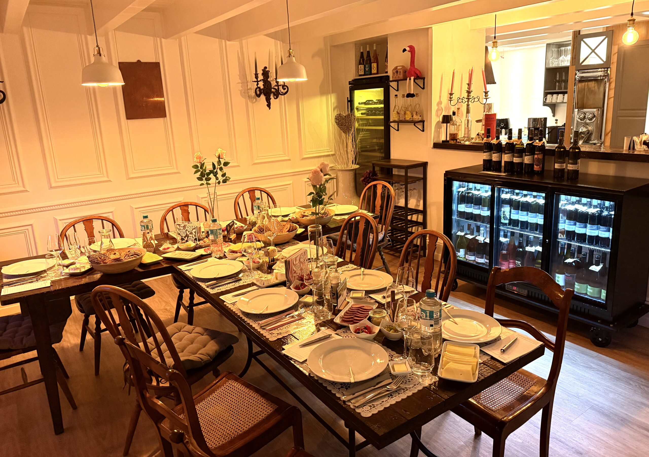 Gedeckter Tisch in der Vinothek mit Weingläsern, Wurst, Käse und Brot für einen Tasting-Abend